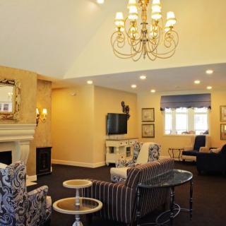 A cozy living room with elegant decor and a large chandelier.