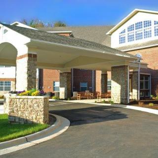 A view of a building entrance with a covered driveway and brick exterior.