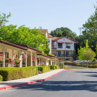 A quiet motel surrounded by lush greenery along a road.
