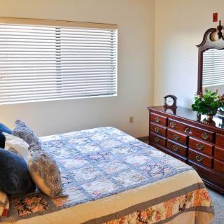 A cozy bedroom with a bed, dresser, and window.