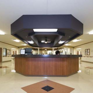 A modern hospital reception desk in a spacious lobby.