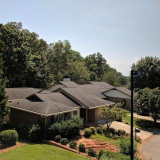 A suburban house with a well-maintained garden and surrounding greenery.
