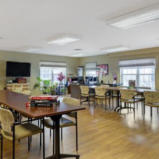 Well-lit common room with tables and chairs for gatherings.