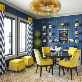 A stylish dining room featuring bold blue walls, vibrant yellow chairs, and modern decor elements.