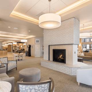 A modern lounge area with a central fireplace and comfortable seating.