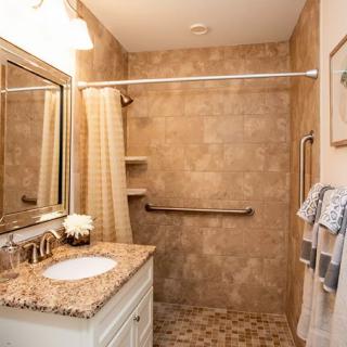 A well-designed bathroom with a walk-in shower, granite countertop sink, and tasteful decor.