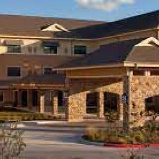 A modern building with a stone exterior and well-maintained landscaping.