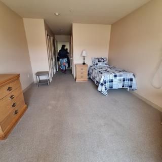 A spacious, empty bedroom with basic furniture.