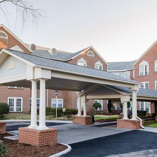 A brick residential building with a covered entrance and driveway.