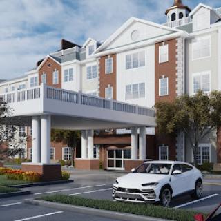 A picturesque hotel with a welcoming entrance and a parked white car in the foreground.