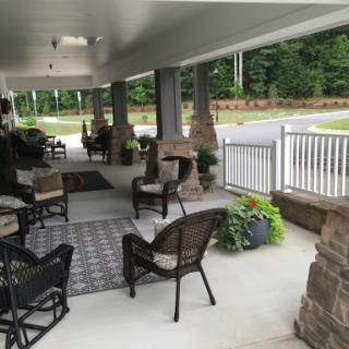 A peaceful outdoor porch area furnished for relaxation, surrounded by nature.