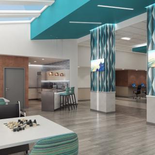 A modern lobby with blue accents, featuring a seating area and a chess board on the table.
