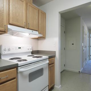 A well-organized kitchen featuring a stove, cabinets, and a clean countertop.