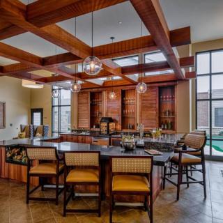 A modern bar interior featuring wooden beams, ample seating, and large glass windows.