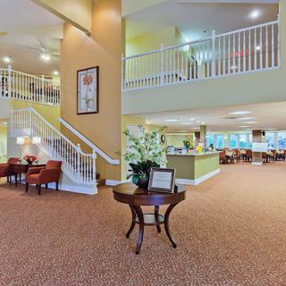 A spacious lobby area featuring a staircase, comfortable seating, and elegant decor.