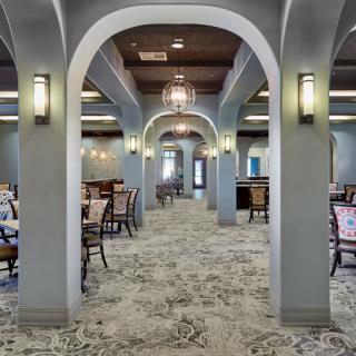 An elegant dining area with arched ceilings and a symmetrical arrangement of tables and chairs.