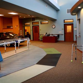 A spacious and brightly lit rehabilitation therapy room equipped for patient exercises.
