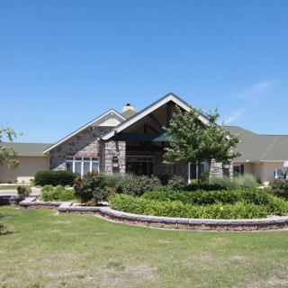 A charming residential house with well-maintained landscaping under a clear blue sky.