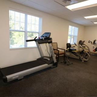 A room featuring fitness equipment, including a treadmill and exercise bikes.