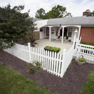 A charming house with a white picket fence and a landscaped front yard.