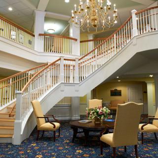 A luxurious hotel lobby featuring a grand staircase and elegant chandelier.