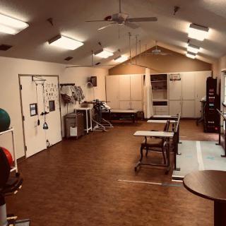 A spacious interior room equipped for physical activities, featuring exercise equipment and tables.