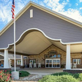 The welcoming entrance of a beautifully designed building under a blue sky.