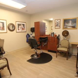 A cozy barber shop interior featuring styling chairs and framed artwork on the walls.