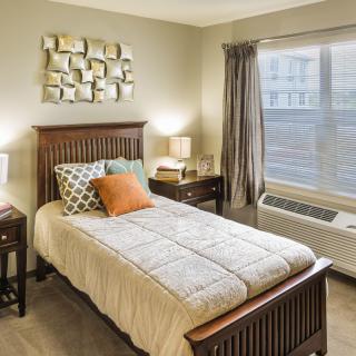 A cozy bedroom with a single bed, modern decor, and abundant natural light.