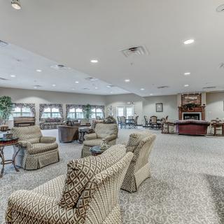 A spacious living room with comfortable seating, a fireplace, and large windows.