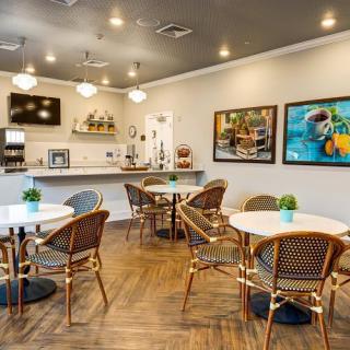 A cozy cafe interior with tables, chairs, and decorative artwork.