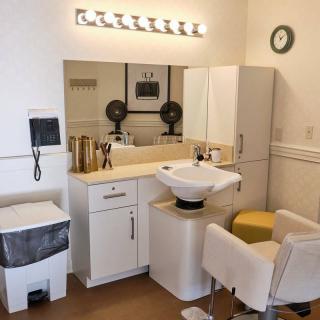 A small, well-organized hair salon with a washing station and styling area.