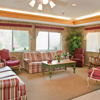 A cozy living room area featuring striped furniture, warm lighting, and large windows.