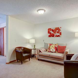 Cozy living room with a sofa, armchairs, and warm decor.