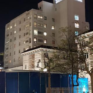 A night view of a building with illuminated windows beside a construction site.