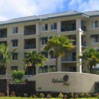 A modern apartment building surrounded by palm trees.