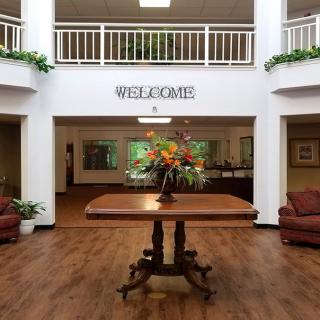 A welcoming lobby area featuring a central table with a floral arrangement and seating on either side.
