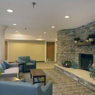 A cozy lounge area with comfortable seating and a stone fireplace.