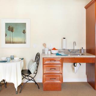A cozy kitchen corner with a small dining table, chairs, and a sink setup.