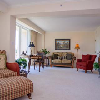A spacious and well-lit living room with comfortable seating and elegant decor.