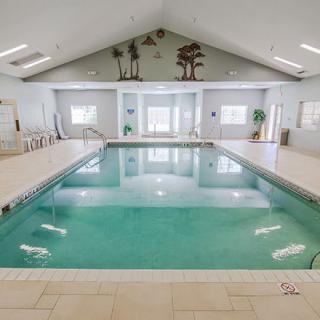 A spacious indoor swimming pool with natural lighting and a high ceiling.
