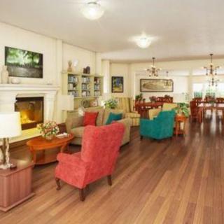 A cozy and spacious living room with colorful furniture and a fireplace.