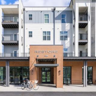 A modern apartment building with a prominent entrance and bicycles parked outside.