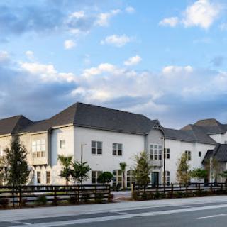 A modern residential building with a picturesque backdrop of clouds in the sky.