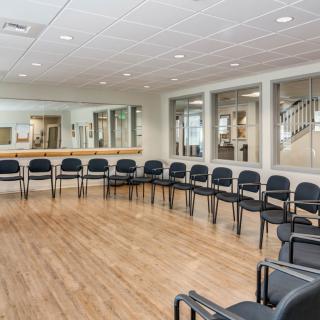 An empty waiting room with chairs arranged in a circle.