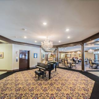 A spacious lobby featuring a grand piano and elegant chandelier.