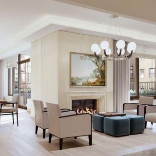 A modern and elegant living room featuring a central fireplace, stylish furniture, and a contemporary chandelier.