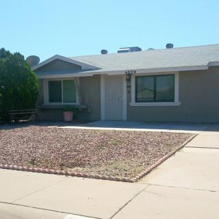A single-story suburban house with a dry landscape front yard and driveway.