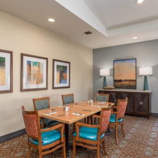 A cozy dining area with a set of tables and chairs, complemented by framed artwork and modern lighting.