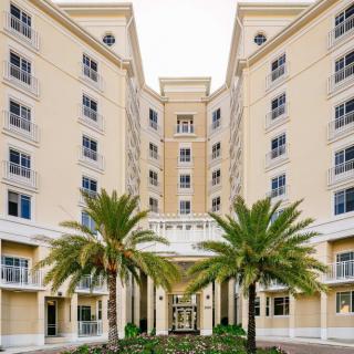 A grand hotel entrance flanked by palm trees with symmetrical architecture.